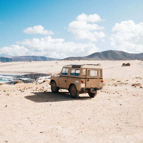 A  shot of an off-road car standing in a wild area by a small lake